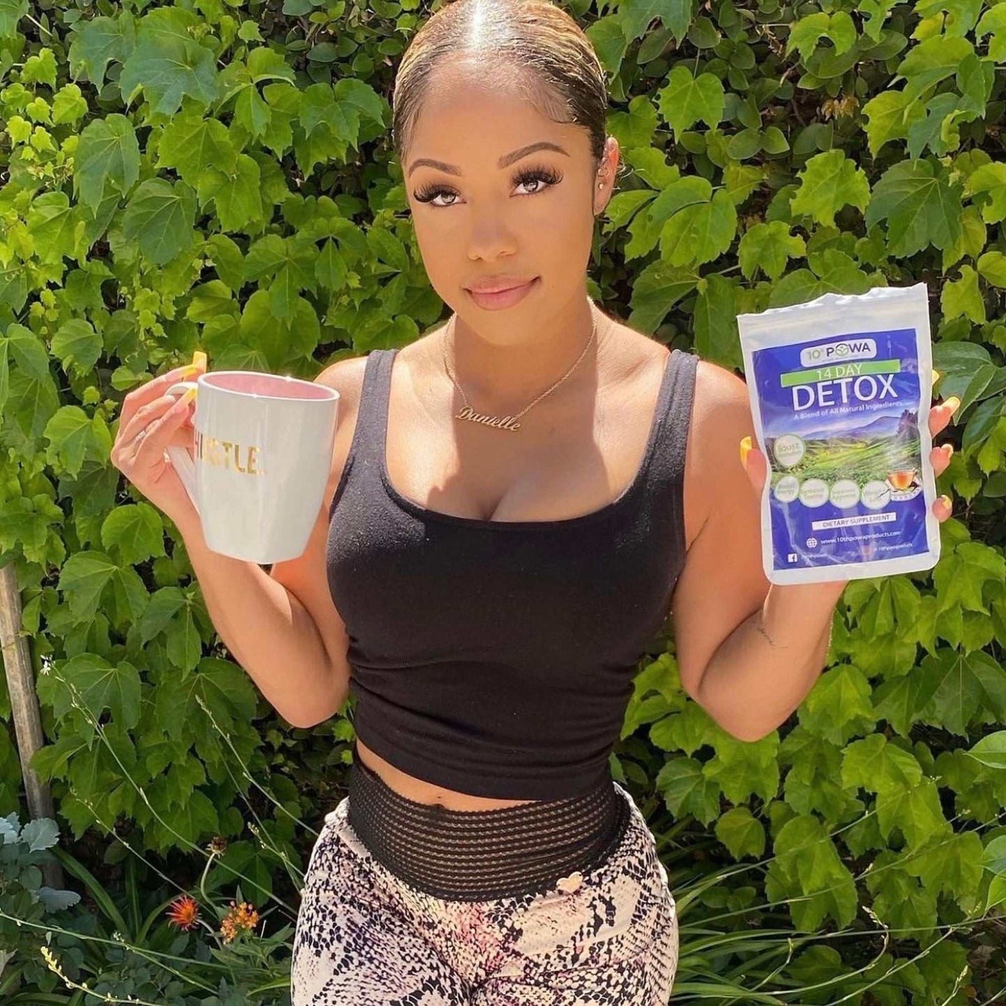 Woman holding colon cleanse detox tea and capsule kit with greenery background